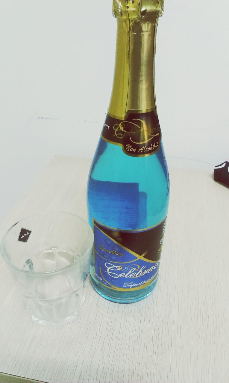 indoors, still life, table, close-up, glass - material, white background, blue, bottle, copy space, no people, drink, transparent, container, studio shot, food and drink, single object, drinking glass, high angle view, wall - building feature, refreshment