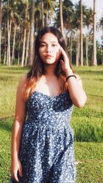 Portrait of young woman standing on field