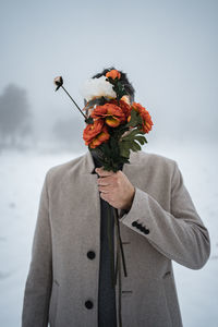 Midsection of person holding rose plant