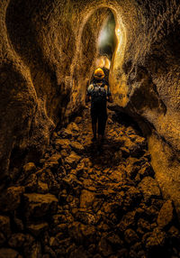 Rear view of man standing in cave