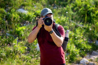 Mountain hiker photographer explores the area for the photographic hunting of wild animals. 