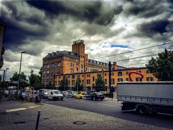 View of city street against cloudy sky