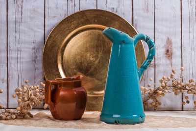 Close-up of jugs with plate on table