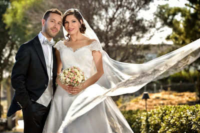 Portrait of wedding couple standing at park