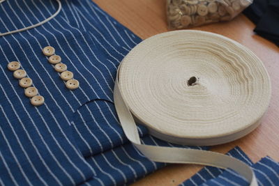 High angle view of blue cloth with sewing items on table