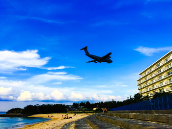 Low angle view of airplane over calm beach