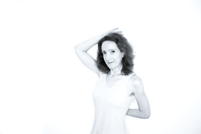 Portrait of a smiling young woman standing against white background