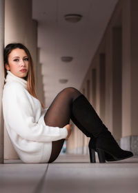 Portrait of young woman sitting on floor