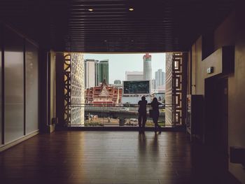 Rear view of couple standing by railing