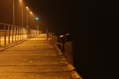 Illuminated street light against sky at night