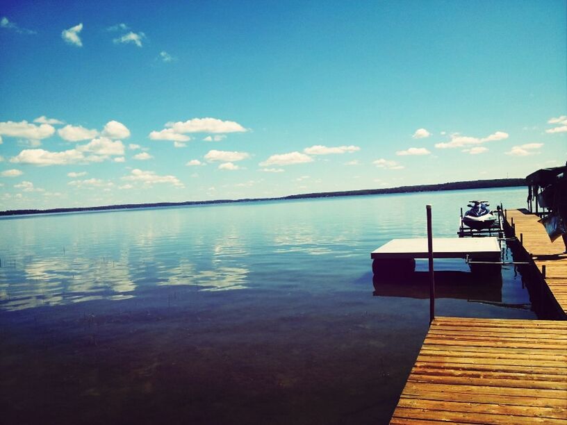 water, sky, lake, tranquility, tranquil scene, scenics, reflection, nature, beauty in nature, pier, cloud - sky, built structure, cloud, blue, building exterior, outdoors, architecture, idyllic, calm, sunlight