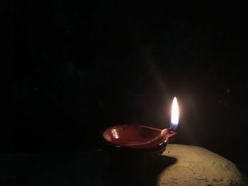 Close-up of lit candle in darkroom