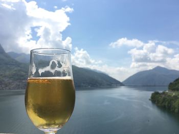 Close-up of beer in glass against mountains