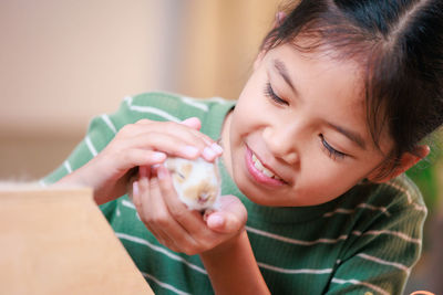 Close-up of girl holding baby rabbit