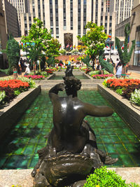 Statue by fountain in city