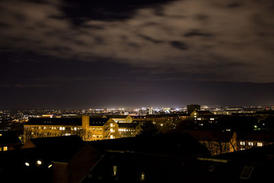 High angle view of illuminated buildings against sky at night