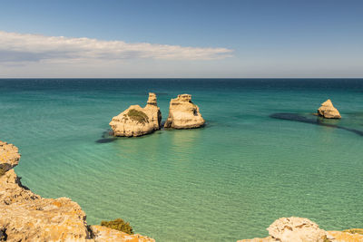 Rocks in sea against sky