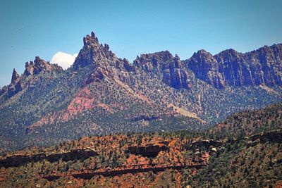 Scenic view of mountains against blue sky