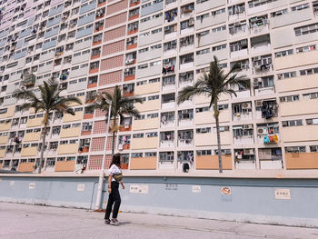 Woman standing on street against buildings in city