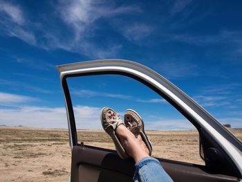 Low section of woman on mirror against sky