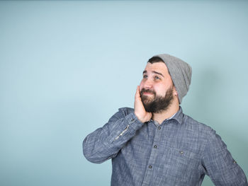 Portrait of man standing against blue background