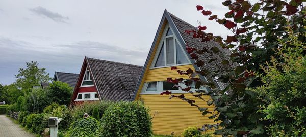 Low angle view of building by trees against sky