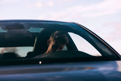 Portrait of man seen through car window