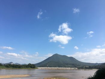 Scenic view of sea and mountains against blue sky