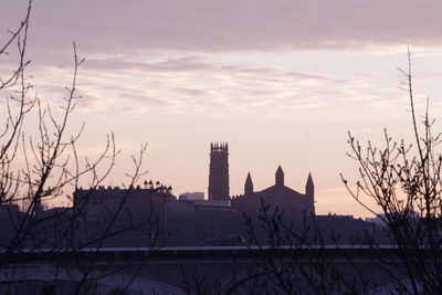 Buildings against sky during sunset in city