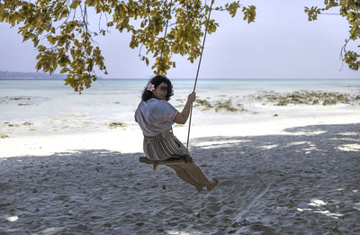 Full length of woman on beach against sky