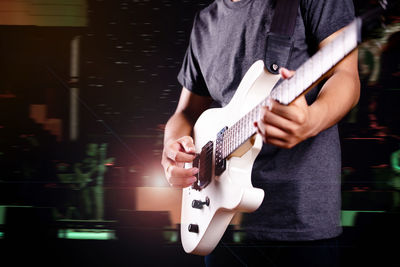 Midsection of man playing guitar