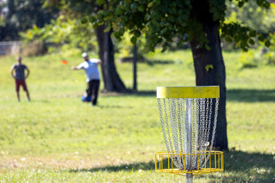 People playing flying disc golf sport game in the public park