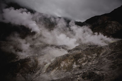 Smoke emitting from volcanic mountain against sky