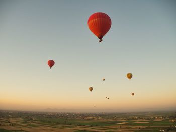 Low angle view of hot air balloons flying against sky during sunset