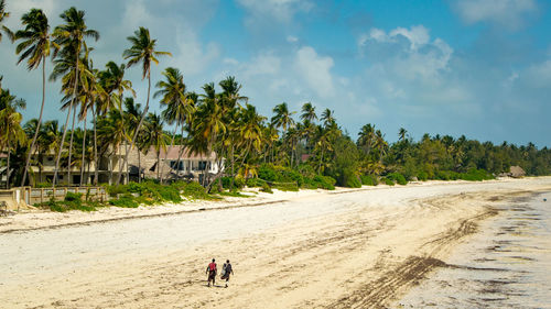 People at beach against sky