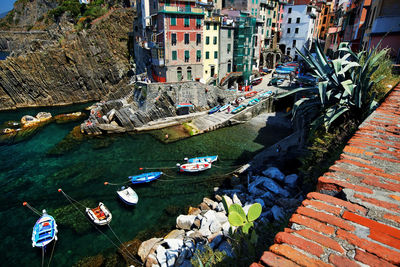 High angle view of boats moored on sea by residential buildings