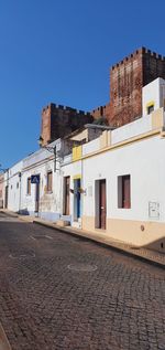 Low angle view of old building against clear blue sky