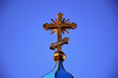 Low angle view of cross against clear blue sky