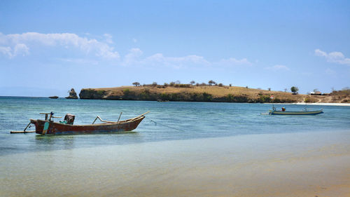 Boat moored on sea against sky