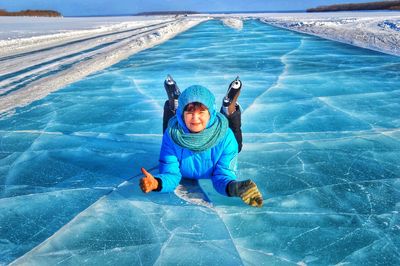 Portrait of mature woman lying on frozen lake