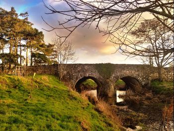 Bridge over river against cloudy sky