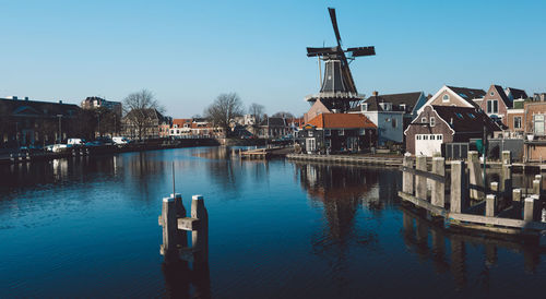 Traditional windmill by river in city