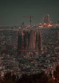 Illuminated buildings in city against sky at night