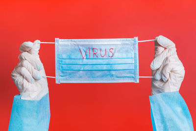 Midsection of women standing against red background