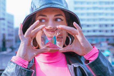 Young woman holding crystal in city