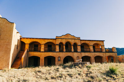 Low angle view of abandoned building against clear blue sky