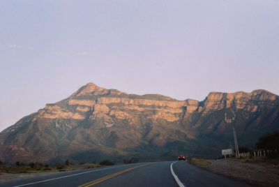 Road by mountain against clear sky