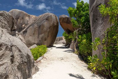 Footpath amidst rocks against sky