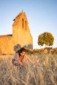 Rear view of woman standing on field against clear sky