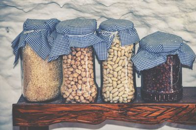 Grains in glass jars on table by wall